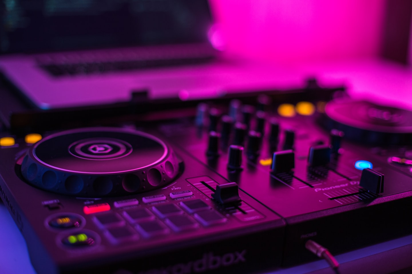 DJ controller with illuminated buttons and jog wheel.